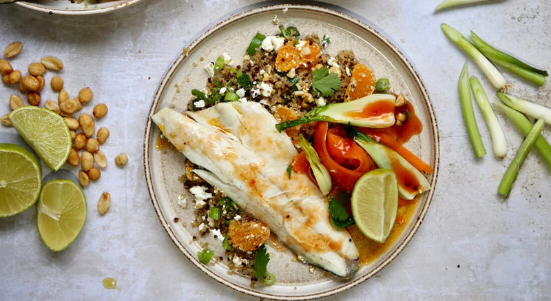 Wolfsbarschfilet auf Quinoa-Salat mit Orangen, Kräutern, Feta und gehackten Erdnüssen