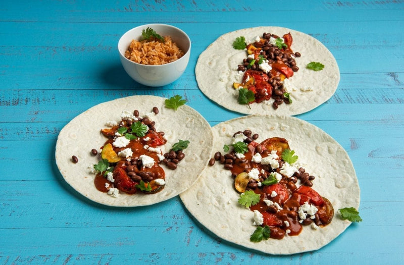 Vegetarische Fajitas mit geröstetem Gemüse, schwarzen Bohnen, Feta und Koriander