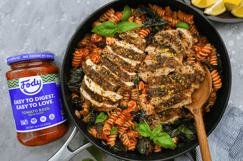 Pasta in Tomaten-Basilikum-Sauce mit Scheiben von Zitronen-Kräuter-Poulet und Basilikum