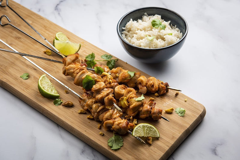 Sweet & Sour Pouletspiesse mit Koriander und gerösteten Nüssen, dazu Jasminreis und Limettenschnitze